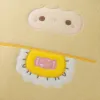 A cute beige cartoon plush pillow with ears and a pink face, featuring candy patterns, is a warm and cozy gift Application Scenario